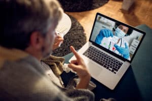 Close up of man having video call with his doctor in the evening