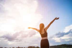 Happy smiling athletic woman with arms outstretched